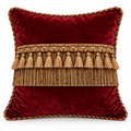Front view of maroon cushion cover with gold tassel band and layered fringe.