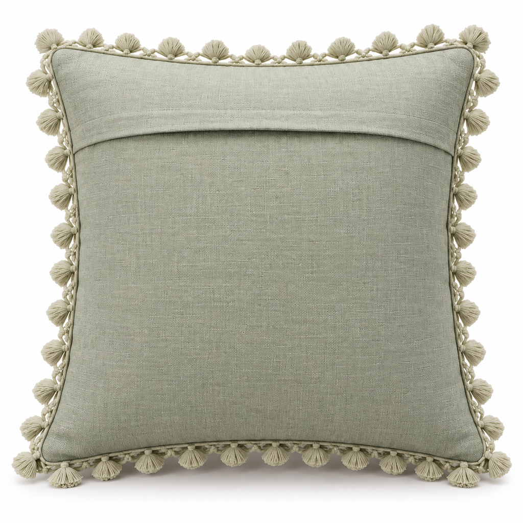Plain sage green back of cushion cover with envelope-style opening and tassel trim.