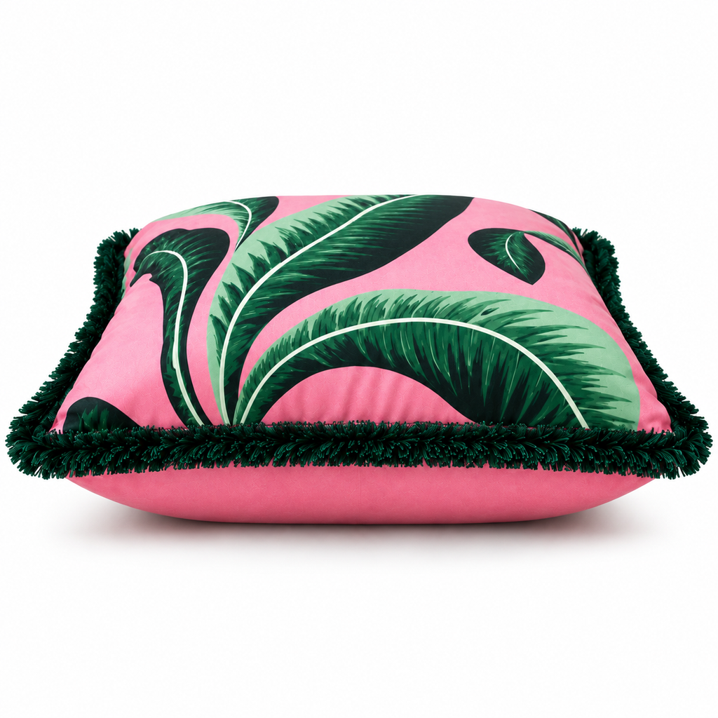 Side view of pink tropical leaf cushion with fringe edging